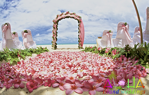Hawaii beach wedding photo with pink themed tropical flowers on the sand
